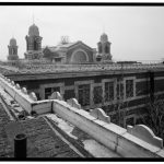 looking_south_along_roof_of_baggage_and_dormitory_building_toward_main_building_statue_of_liberty_is_visible_under_scaffolding_at_far_right_-_ellis_island_main_building_new_habs_ny31-ellis1c-11